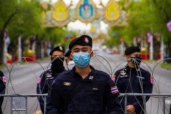 A Thai police officer stands beside a barricade during anti-government protests in Bangkok, Thailand, June 26, 2021. (Tommy Walker/VOA)