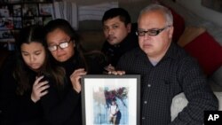 Cassandra Quinto-Collins, second from left, holds a photo of her son, Angelo Quinto, while sitting with daughter Bella Collins, left, son Andrei Quinto, center, and husband Robert Collins during an interview in Antioch, Calif., March 16, 2021. 