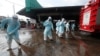 Workers clean the road outside shrimp market in Samut Sakhon, Bangkok, Jan. 25, 2021, as Thailand registered a new daily high of over 900 cases of the coronavirus at the province near the capital Bangkok, where a major outbreak occurred in December.