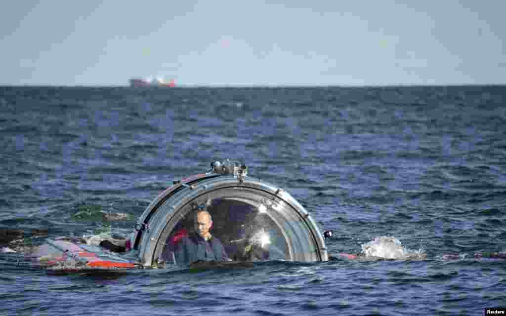 Russia&#39;s President Vladimir Putin (L) is seen through the glass of C-Explorer 5 submersible after a dive to see the remains of the naval frigate &quot;Oleg&quot,; which sank in the 19th century, in the Gulf of Finland in the Baltic Sea. 