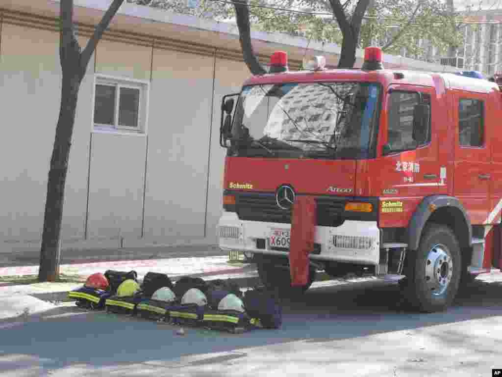 消防车严阵以待，消防衣帽整齐地摆在车前，以备不时之需