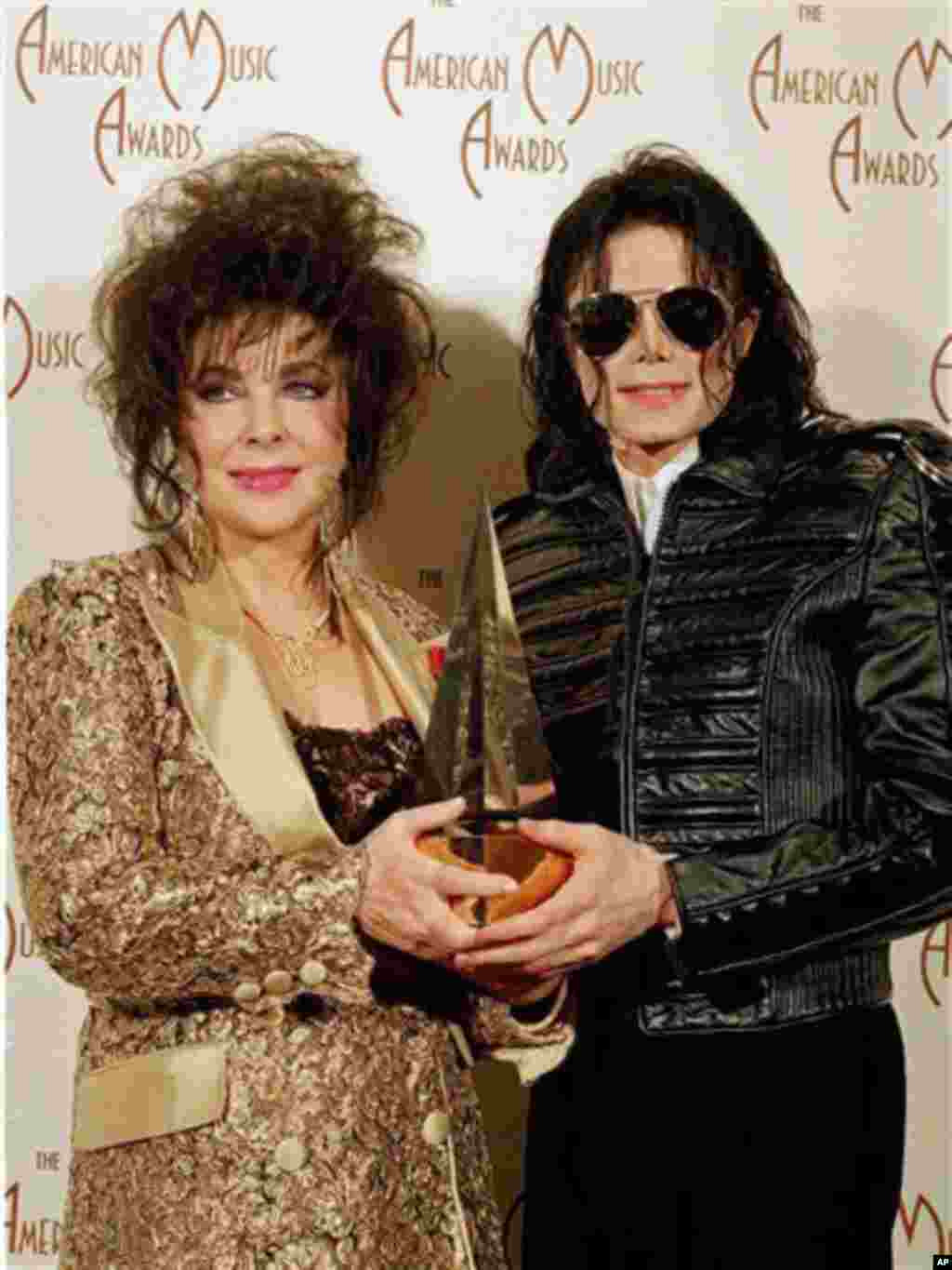 Pop singer Michael Jackson, right, holds his award while posing with actress Elizabeth Taylor at the 20th American Music Awards held at the Shrine Auditorium in Los Angeles, January 25, 1993 - AP