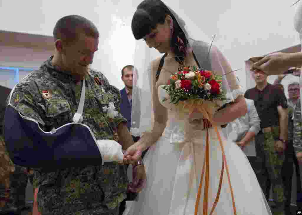 Donetsk People&#39;s Republic platoon commander Arsen Pavlov, also known as Motorola, and Elena Kolenkina exchange rings during their wedding ceremony in the city of Donetsk, eastern Ukraine.