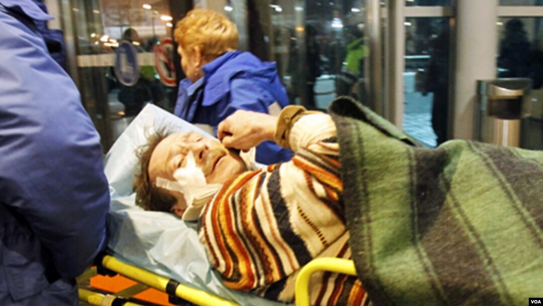 Petugas paramedis membawa salah satu korban yang terluka meninggalkan bandara Domodedovo, Senin (1/24).