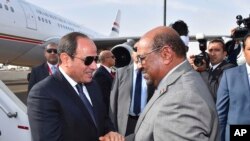 In this photo released by the Egyptian Presidency, Egyptian President Abdel-Fattah el-Sissi, left, is greeted by Sudanese President Omar al-Bashir on his arrival to Khartoum, Sudan, Thursday, July 19, 2018.