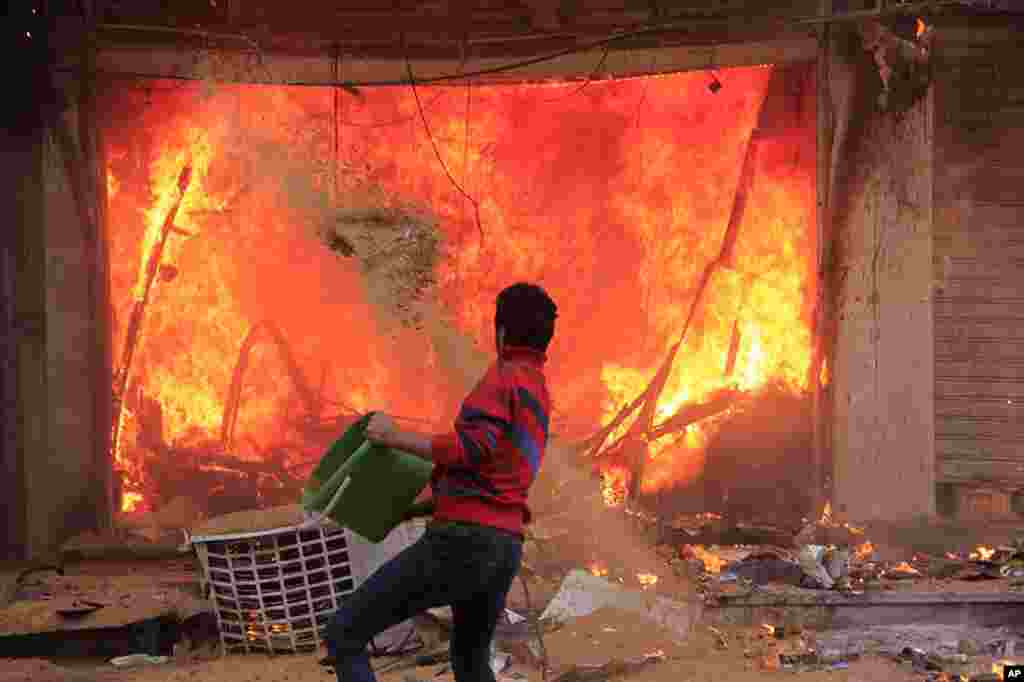 A civilian tries to put out a fire caused by the Muslim Brotherhood supporters during clashes near the Giza Pyramids in Giza, Egypt.