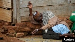 An internally displaced Muslim man lies in front of a house in the town of Boda, Central African Republic, April 15, 2014.