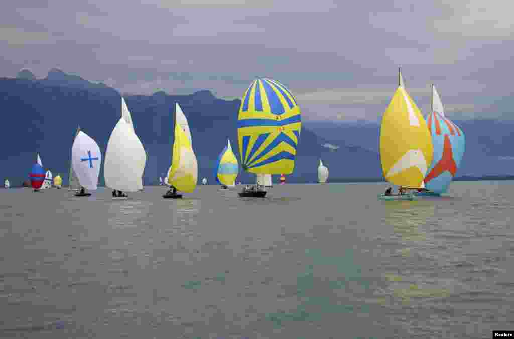 Wooden sailing boats take part in an exhibition regatta on Lake Leman near La Tour-de-Peilz, Switzerland, July 26, 2014.