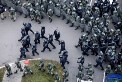 Belarusian riot police block the road to stop demonstrators during an opposition rally to protest the official presidential election results in Minsk, Belarus, Nov. 15, 2020.