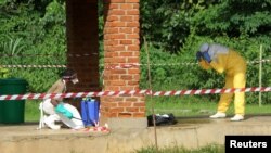 A health worker is sprayed with chlorine after visiting the isolation ward at Bikoro hospital, which received a new suspected Ebola case, in Bikoro, Democratic Republic of Congo, May 12, 2018. 