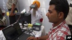 An Indian Sikh (C) looks through an optical biometric reader, which scans and individual's iris patterns, during registration for Aadhaar cards or Unique Identification (UID) cards in Amritsar, (File May 24, 2011).