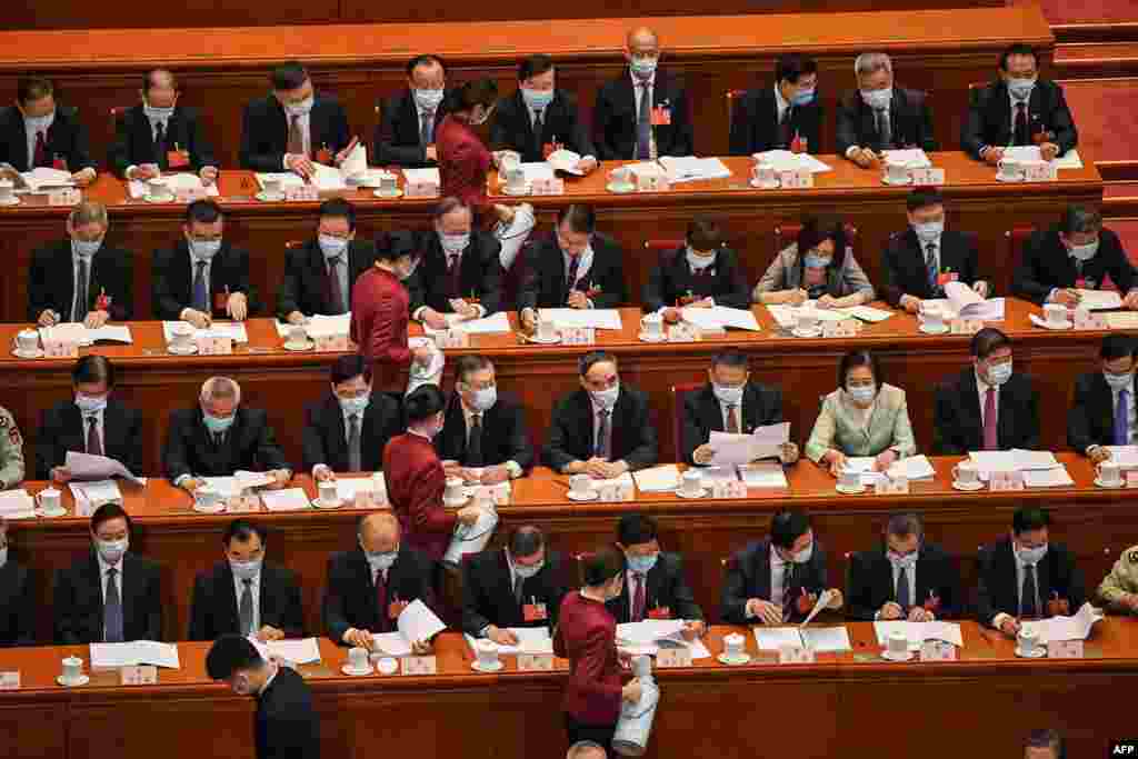 Hostesses serve tea to delegates during the opening session of the National People's Congress (NPC) at the Great Hall of the People in Beijing.