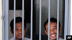 Rohmat Puji Prabowo (alias Bejo) (L) and Supono (alias Kedu) wait inside a cell at the South Jakarta court in Jakarta, 22 Jun 2010