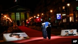 Pictures of Josephine Baker adorn the red carpet as the coffin with soils from the U.S., France and Monaco is carried towards the Pantheon monument in Paris, France, Tuesday, Nov. 30, 2021. (AP Photo/Christophe Ena)