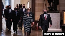 FILE PHOTO: House impeachment managers walk the article of impeachment against former U.S. President Donald Trump through the Rotunda of the U.S. Capitol