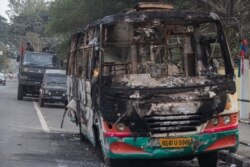 Indian army vehicles are parked behind a bus which was burnt by protesters during a protest against the Citizenship Amendment Bill in Gauhati, India, Dec. 13, 2019.