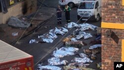 Yangında hayatını kaybedenlerin cesetleri binanın yanına konuldu