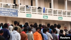 FILE - Multinational victims of scam centers, who were trafficked into working in Myanmar and were sent to Thailand on Feb. 12 amid a mounting crackdown on scam centers queue to get food as they wait for their embassies to pick them up, in Tak province, Thailand, Feb. 19, 2025. 