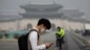 A student wearing a mask uses his mobile phone during a polluted day in Seoul, South Korea, March 5, 2019. 