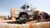 FILE - Boys from the Kassab camp for Internally Displaced Persons (IDP) collect water in Kutum, North Darfur.