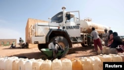 FILE - Boys from the Kassab camp for Internally Displaced Persons (IDP) collect water in Kutum, North Darfur.