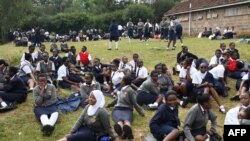 Students sit at the St. George's Girls' Secondary School as they wait to be picked up after learning classes were called off due to the spreading of the COVID-19 coronavirus, in Nairobi on March 17, 2020.
