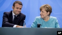 Presiden Prancis Emmanuel Macron (kiri) dan Kanselir Jerman Angela Merkel (kanan) menghadiri konferensi pers seusai pertemuan menjelang KTT G-20 di Berlin, Jerman, Kamis, 29 Juni 2017. (Michael Kappeler / dpa via AP)