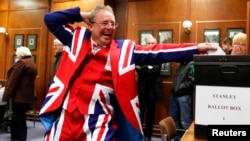 A Falkland Islander gestures as he casts his vote at the Town Hall polling station in Stanley, Mar. 10, 2013.