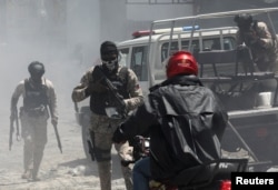 FILE - Police officers patrol after dispersing protesters, who called for help from the government and security forces after mobs attacked neighborhoods and set fire to homes, in Port-au-Prince, Haiti, August 19, 2024.