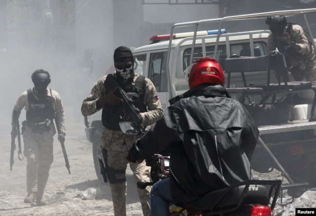 FILE - Police officers patrol after dispersing demonstrators, who were calling for help from the government and security forces after gangs attacked neighborhoods and set houses on fire, in Port-au-Prince, Haiti, Aug. 19, 2024.