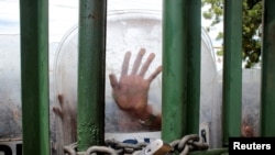 A riot police officer blocks the entrance of Central American University (UCA) during a protest against the government of Nicaraguan President Daniel Ortega, in Managua, Nicaragua, Nov. 19, 2019. 