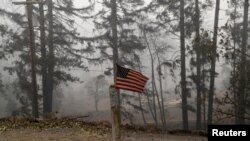 A U.S. flag is taped to the pole at the entrance of a house destroyed by fire in the aftermath of the Beachie Creek fire near Gates, Oregon, Sept. 14, 2020. 