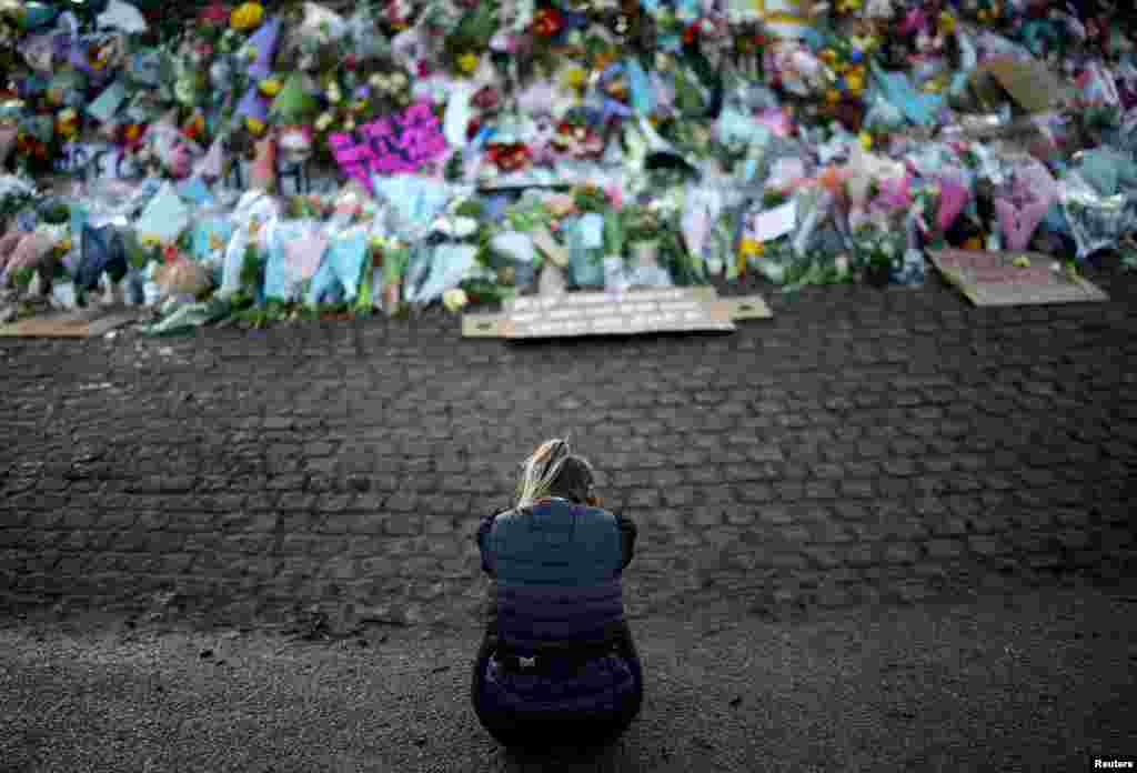 A mourner sits in front of a memorial site at the Clapham Common Bandstand, following the kidnap and murder of Sarah Everard, in London, Britain.