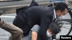 Seorang pria, diyakini sebagai tersangka penembakan mantan Perdana Menteri Jepang Shinzo Abe ditahan oleh petugas polisi di Stasiun Yamato Saidaiji di Nara. (Foto: Reuters)