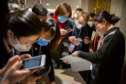 FILE - Journalists look at a government statement prior to a press conference about the coronavirus outbreak, in Beijing, China, Jan. 26, 2020. Meanwhile, citizen journalists are challenging the official narrative with their own reporting.