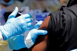 FILE - A health worker injects a man with Ebola vaccine in Goma, Democratic Republic of the Congo, Aug. 5, 2019.