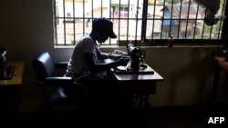 FILE - A victim of human trafficking in Libya sews clothes in Benin, Edo State, Nigeria, Oct. 21, 2016. Human Rights Watch says in a new report that Nigerian trafficking survivors are not getting enough support from their government.