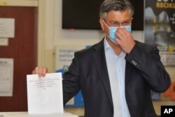 آندری پلنکوویچ نخست وزیر کرواسی رأی خود را به صندوق می‌اندازد