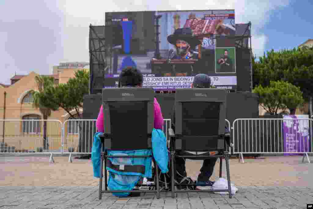 People watch on a large screen the funeral service for Anglican Archbishop Emeritus Desmond Tutu at the St. George&#39;s Cathedral in Cape Town, South Africa, Jan.1, 2022.