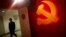 A trainee walks pass a communist party logo as he attends a training course at the communist party school called China Executive Leadership Academy, Sept. 2012.