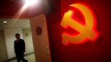 A trainee walks pass a communist party logo as he attends a training course at the communist party school called China Executive Leadership Academy, Sept. 2012.