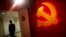 A trainee walks pass a communist party logo as he attends a training course at the communist party school called China Executive Leadership Academy, Sept. 2012.