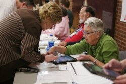 Volunteers register caucusers at a caucus site at Sparks High School for the Nevada Democratic presidential caucuses in Reno, Nevada, Feb. 22, 2020.