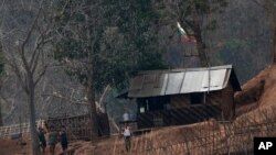 FILE - In this March 30, 2021, photo, Myanmar soldiers stand at a small army camp along the river bank near the border of Myanmar and Thailand. Ethnic Karen guerrillas said they captured the Myanmar army base Tuesday, April 27, 2021.