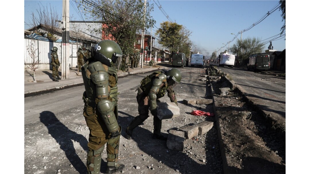 Police clear a barricade during clashes demanding food aid from the government during the COVID-19 lockdown, at a poor neighborhood in Santiago, Chile, Monday, May 18, 2020.