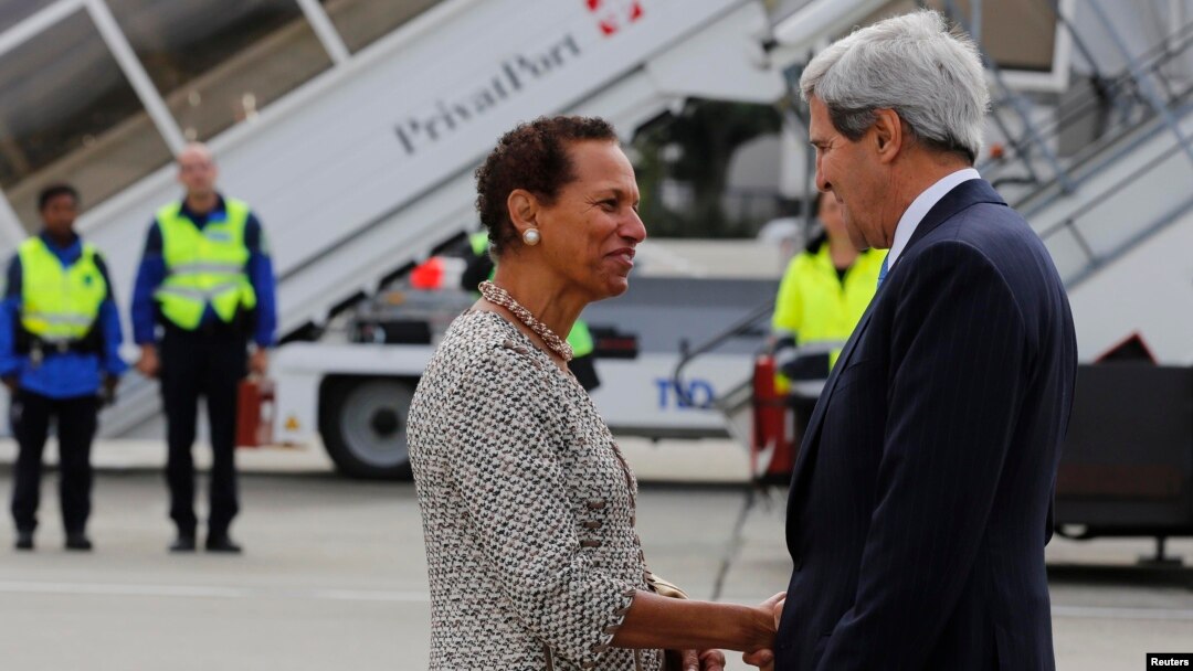 Bộ trưởng Ngoại giao Mỹ John Kerry bắt tay với đại diện thường trực của Hoa Kỳ tại Liên Hiệp Quốc, Ðại sứ. Betty E. King, sau khi ông đến Cointrin tại Geneva, ngày 12/9/2013.