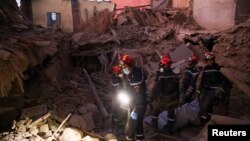 Emergency workers carry bodies following a historic deadly earthquake in Morocco, Sept.10, 2023. 