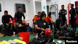 A group of divers prepares their gear on the deck of the Search and Rescue (SAR) ship KN Purworejo during a search operation for passengers onboard AirAsia Flight 8501 in the Java Sea, Jan. 4, 2015. 