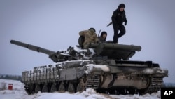 (FILE) Ukrainian soldiers practice on a tank during military training, in Ukraine, Wednesday, Dec. 6, 2023. 