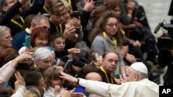 Pope Francis salutes faithful in the Paul VI Hall at the Vatican at the end of an audience with members of parish evangelization services, Nov. 18, 2019. 